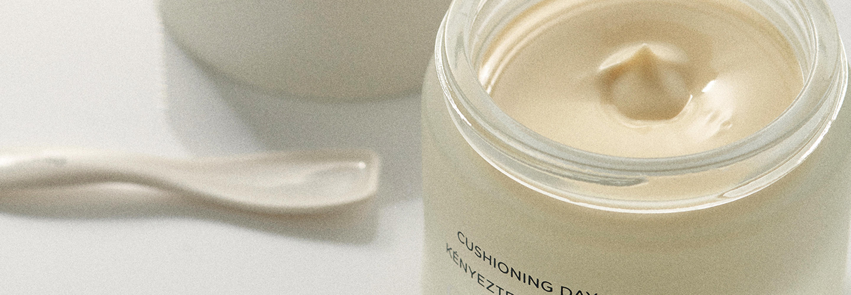 open jar of omorovicza cushioning day cream with a spatula