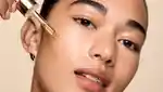 Close up of girl holding a dropper to her cheek