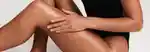 model applying body oil to their leg