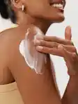 close up of girl applying body cream on her shoulder