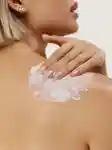 close up of cream being applied onto back shoulder