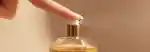 finger pushing the spray of gisou honey infused hair perfume