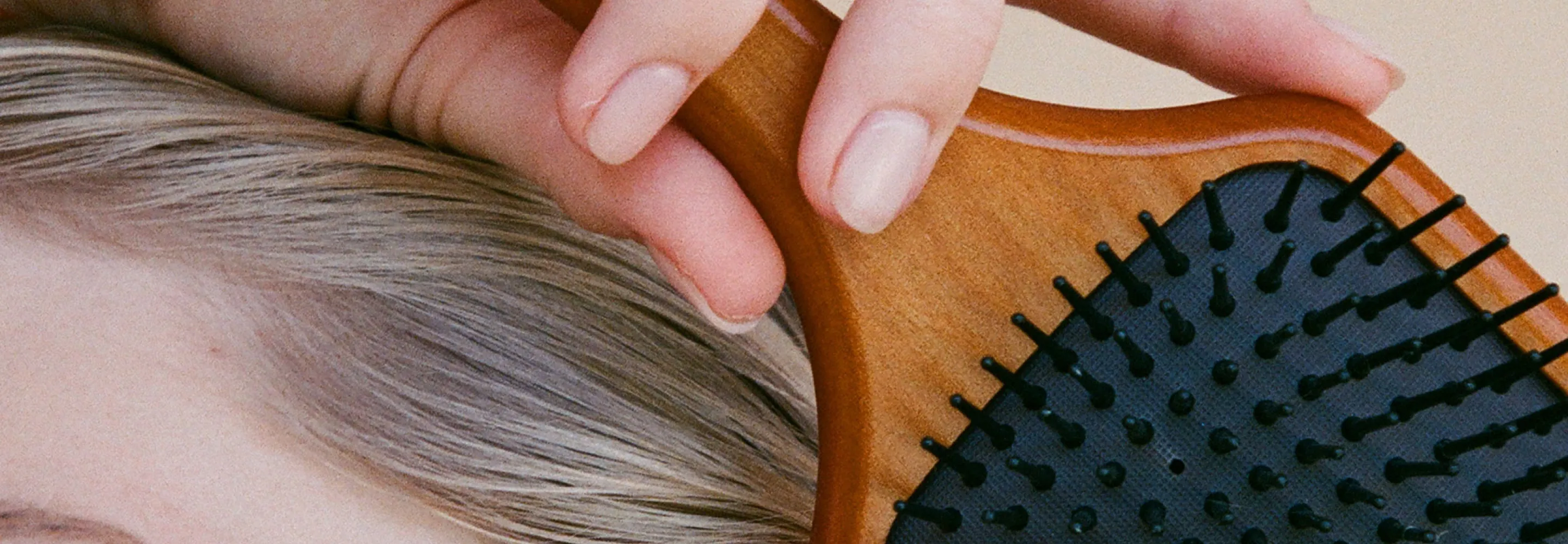 model holding the aveda paddle brush