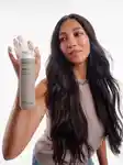 Model holding bottle of No Frizz Shampoo