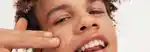 model applying concealer to their cheek with two fingers