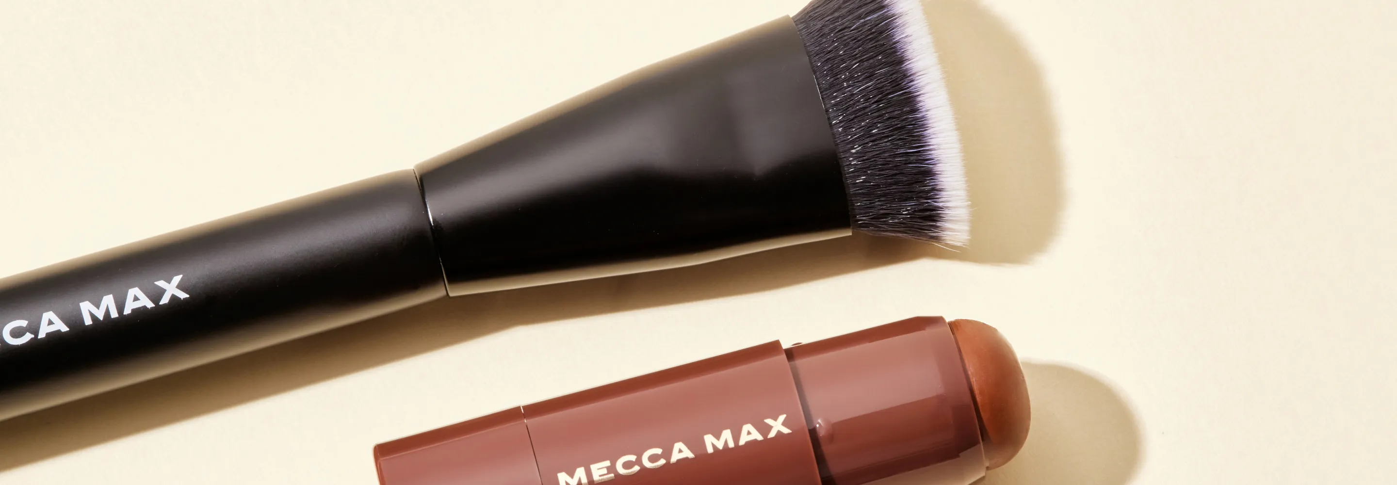 mecca max cheek chiseler brush lying next to the mecca max off duty contour stick