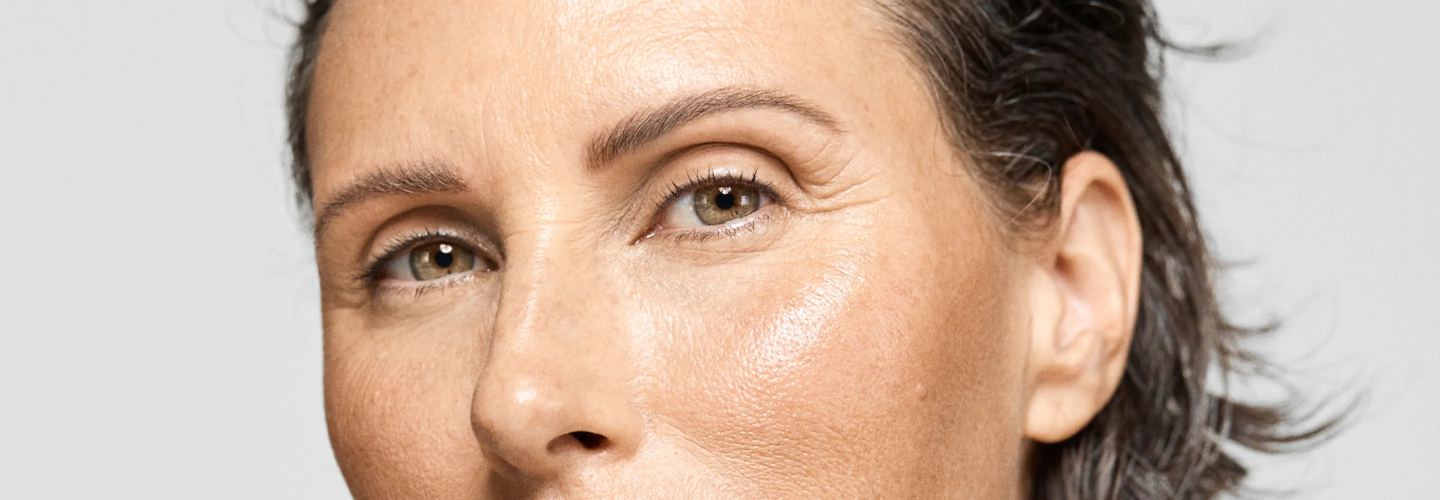 a model looking into the camera with intense highlighter on their cheekbone