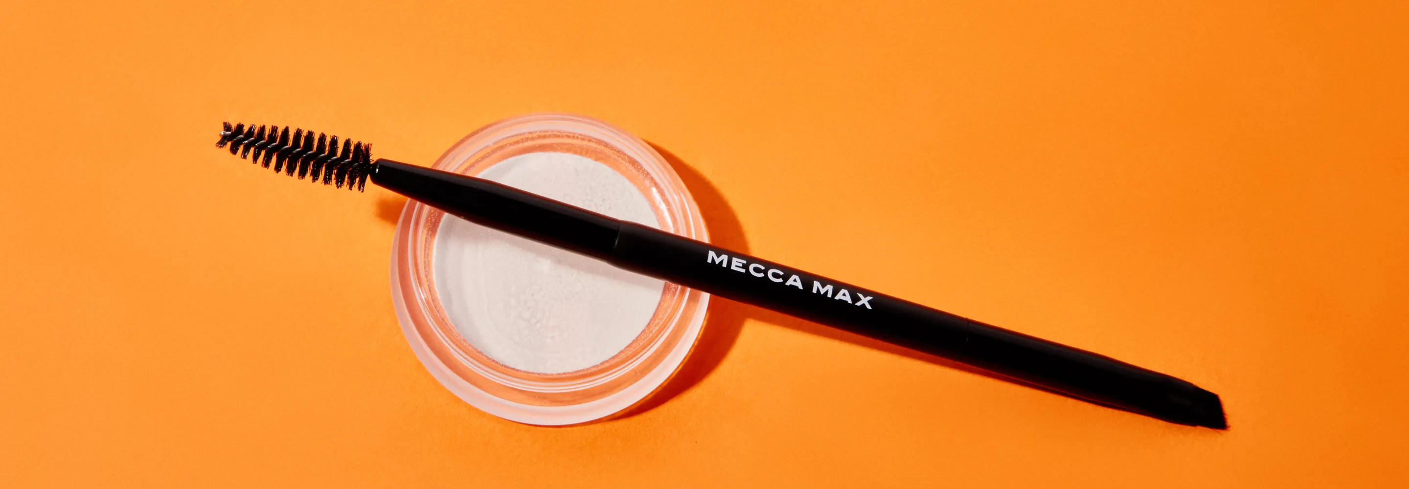 mecca max brow artist brow brush laying on top of the mecca max brow guru super soap