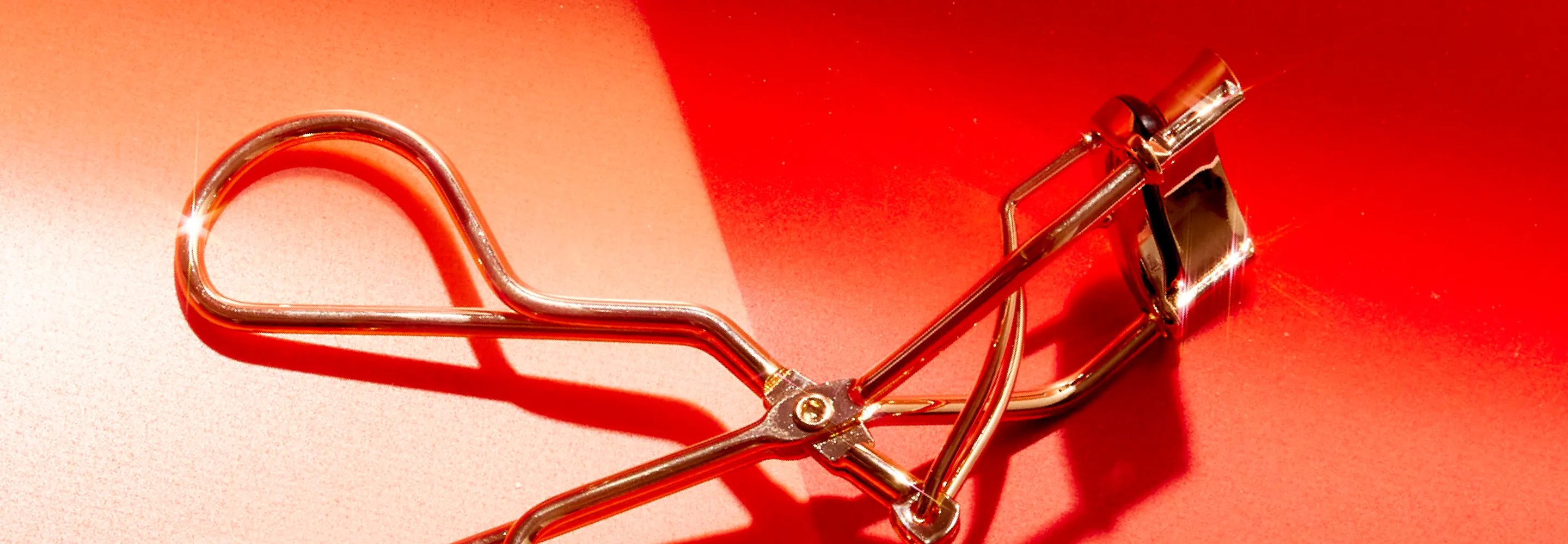 gold eyelash curler lying flat