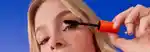 a model applying the mecca max eye max mascara to their eyelashes