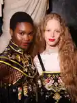 Two models standing together backstage