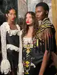 Three models posing for a photo backstage