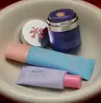 Three sunscreens close up in a ceramic sink