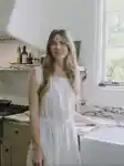 Moon Juice Founder Chantal Bacon in her kitchen in California wearing a white dress