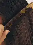 Model runs a comb through her hair.