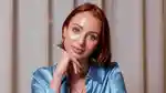 Close up of therapist Chantelle Otten – a young woman with short red hair – resting her cheek on her hand in thought.