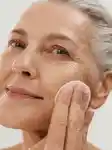Mature lady using face essence in her skincare routine