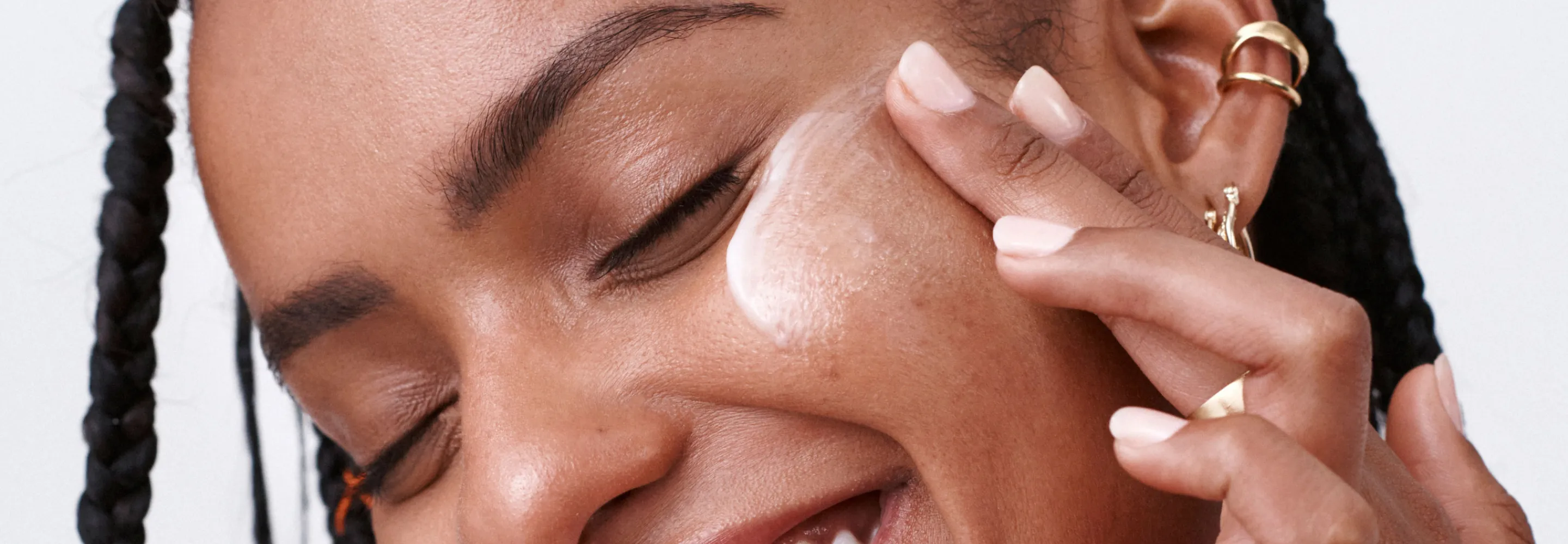 model applying a cream to their cheek