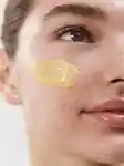 close up of half of a girl's face with skincare product on her cheek